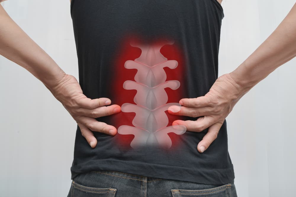 Man experiencing spinal discomfort or back pain.