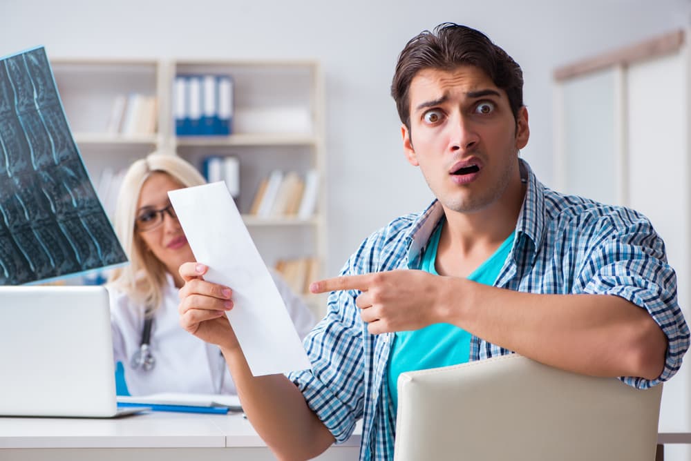 Man frustrated over high medical bill, expressing anger or dissatisfaction with healthcare costs.