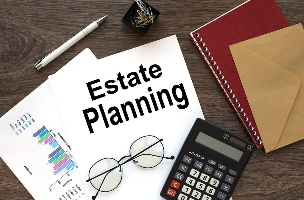 Estate planning on the work desk there is a red notepad and an envelope near the calendar and calculator.
