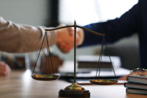 a lawyer and a client shaking hands over a table