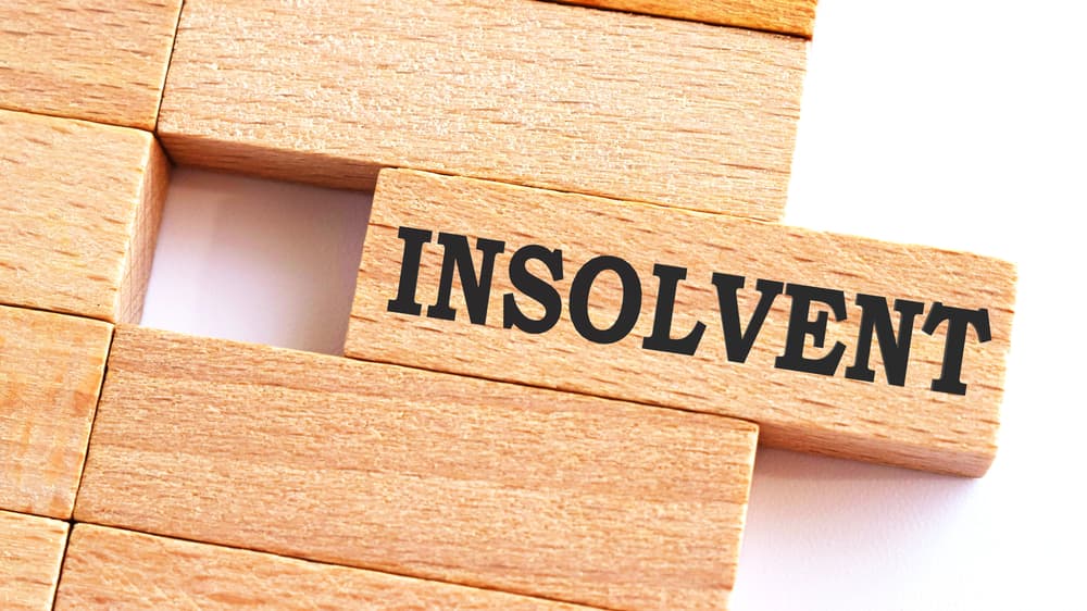 INSOLVENT word written on wood block.
