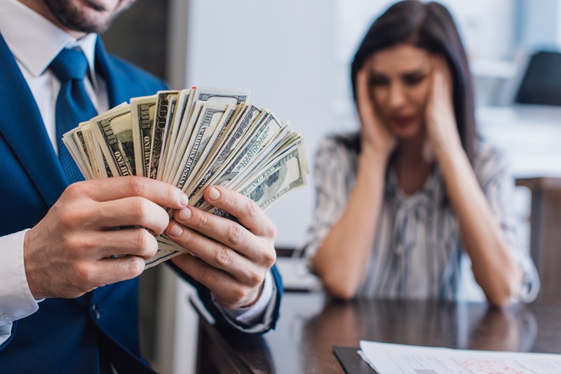 Closeup of a debtor collecting money from an estate. The personal representative is stressed in the background.