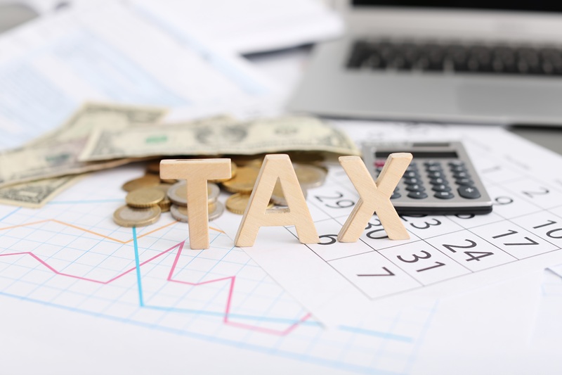 Word TAX, money and calculator on table
